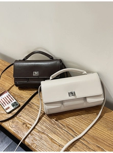 Close-up of retro square handbags in brown and beige with silver rotating metal locks
