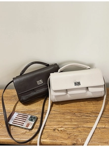 Detail view of the silver metal twist-lock closure on minimalist leather handbags