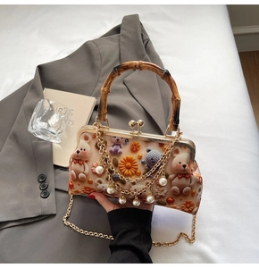 Detail of bear shell bag featuring bamboo handle and elegant pearl metal chain