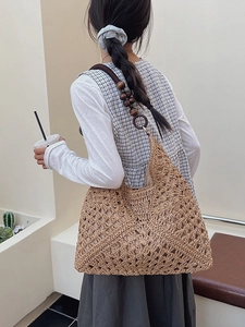 Handmade woven straw tote bag with brown wooden bead straps for summer beach vacations