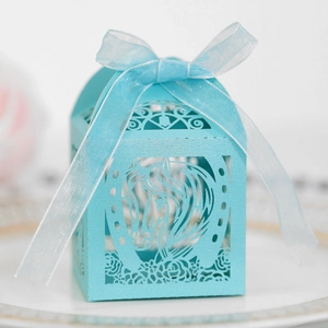 Détail de la boîte cadeau bleue découpée au laser avec motifs de chevaux et nœud élégant