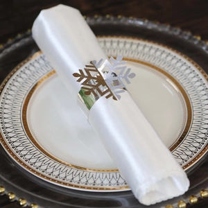 Macro view of silver hollow snowflake napkin ring on a white plate for Christmas dinner