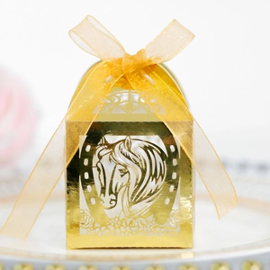 Détail boîte cadeau mariage dorée découpée au laser avec motif de cheval et ruban satin