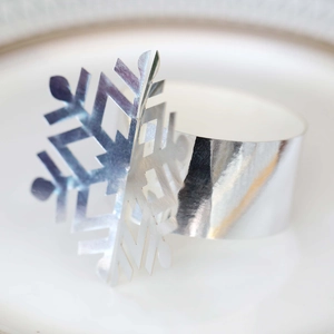 Close-up of a silver mirror-finish snowflake napkin ring with intricate hollowed-out details