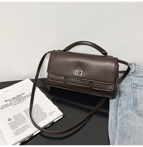 Detailed view of dark brown leather handbag with silver metallic square twist lock