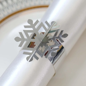 Detailed view of silver snowflake napkin ring on white satin fabric for Christmas