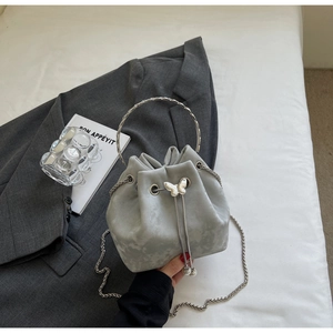 Detail of grey tie-dye bucket bag featuring silver butterfly clasp and metal chain strap