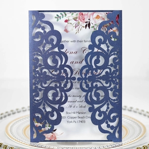 Détail macro de l'invitation de mariage bleue découpée au laser avec carte florale