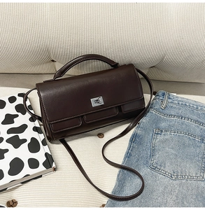 Detailed close-up of dark brown leather handbag with silver hardware and pockets