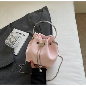 Detail of pink satin bucket bag with silver butterfly drawstring and pearl accents