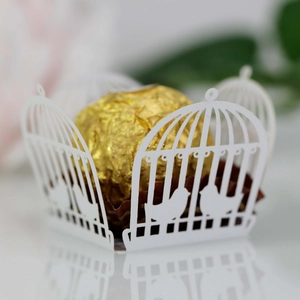 Macro detail of white laser-cut birdcage pattern wrapper for wedding chocolate decor