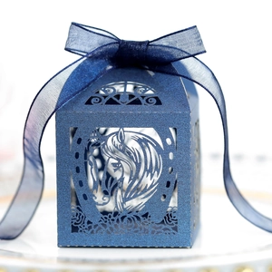 Détail macro du motif de cheval découpé au laser sur une boîte cadeau bleu marine élégante