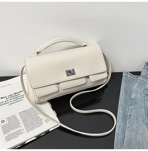 Detail of a chic cream leather small square bag with silver hardware and three flap pockets