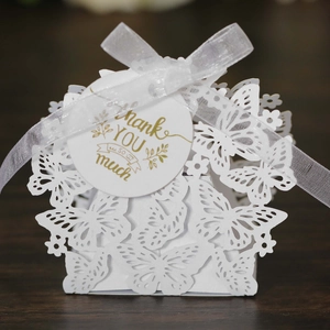 Macro view of white laser-cut butterfly gift box with ribbon and thank you tag