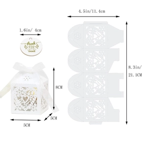 Close-up of white laser-cut favor box with heart pattern and thank you tag detail