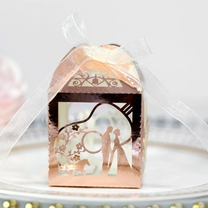 Boîte de dragées mariage découpée au laser or rose avec carrousel et ruban en blanc