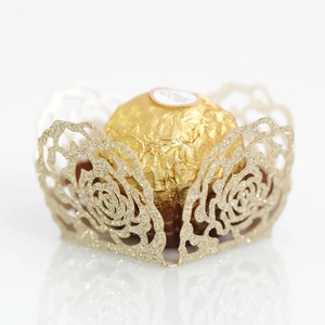Macro shot of glittery gold laser-cut rose chocolate wrapper with hollow petals