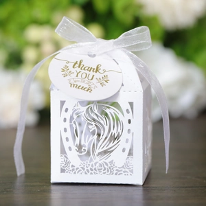 Détail de la boîte cadeau blanche découpée au laser avec motif cheval et ruban blanc