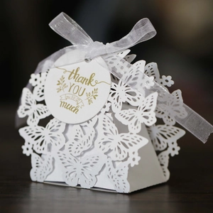 Detailed macro view of a white laser-cut butterfly gift box with a thank you tag