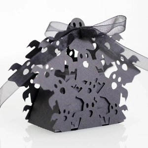 Detail of laser-cut ghost silhouettes on black Halloween candy gift box with ribbon