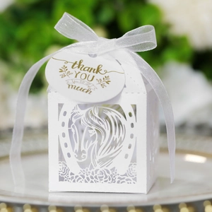 Détail de la boîte cadeau blanche découpée au laser avec motif de cheval et ruban