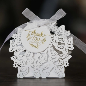 Detail of white laser-cut butterfly candy box with mesh ribbon and thank you tag