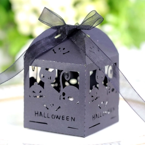 Macro view of laser-cut Halloween candy box with pumpkin, cat, and skull motifs
