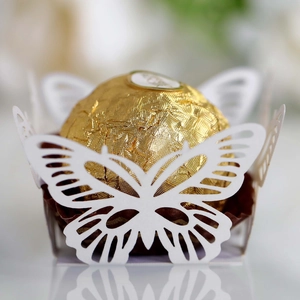Detailed macro view of laser-cut white butterfly paper liner for wedding candies