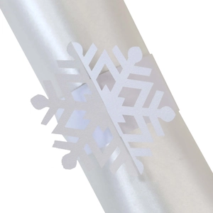 Close-up of white snowflake napkin ring with hollow design for Christmas table decor