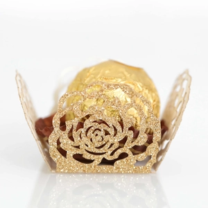 Macro view of gold glitter laser-cut rose pattern for chocolate packaging decoration