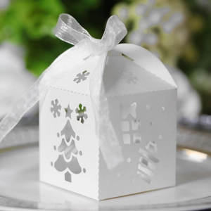 Detail of white laser-cut Christmas gift box with snowflake patterns and silk ribbon