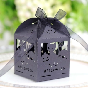 Close-up of laser-cut Halloween candy box featuring cat and pumpkin with black ribbon