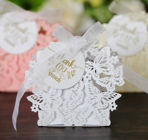 Detail of laser-cut butterfly gift box with silk ribbon and gold thank you tag