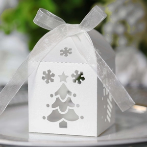 Elegant white laser-cut Christmas tree candy box with snowflakes and a white ribbon