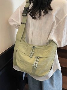 Light green nylon messenger bag with adjustable strap and dual zipper for daily use