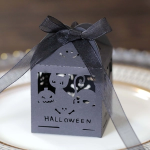Macro shot of black Halloween candy box with laser-cut pumpkin, cat and ghost patterns