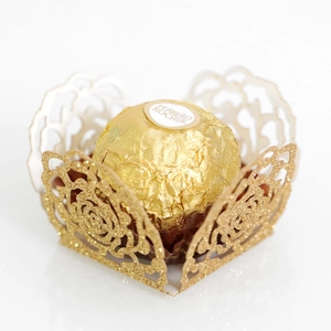 Macro view of gold laser-cut rose hollow chocolate wrapper with glitter finish
