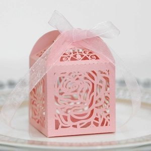 Pink laser-cut candy box with rose pattern and white organza ribbon bow detail