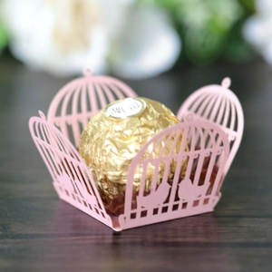 Detail of pink laser-cut birdcage candy box with intricate silhouette for wedding decor