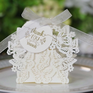 Detailed laser-cut butterfly wedding favor box with white ribbon and thank you tag
