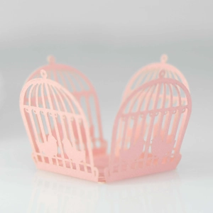 Detail of pink laser-cut birdcage candy box with intricate bird and lattice patterns
