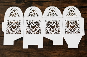 Detailed macro view of laser-cut heart pattern on flat white wedding candy box template