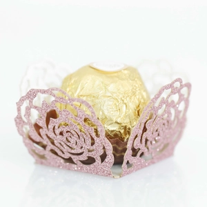 Macro shot of rose gold glitter laser-cut chocolate wrapper with delicate rose pattern