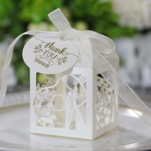 Détail d'une boîte de mariage découpée au laser avec ruban blanc et étiquette merci