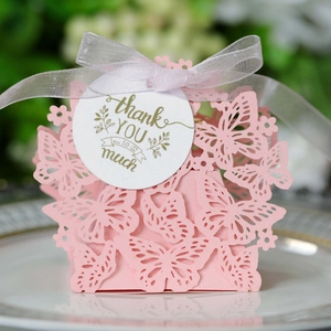 Detail of pink laser-cut butterfly gift box with white ribbon and thank you tag