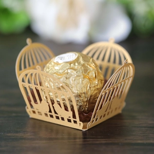 Detail showing golden laser-cut birdcage chocolate wrapper with intricate bird pattern