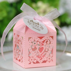 Detailed laser-cut heart pattern on pink wedding favor box with a white thank you tag