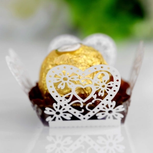 Close-up of laser-cut heart chocolate box with white lace pattern and floral hollow detail