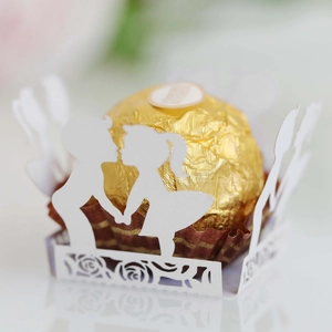 Macro shot of white laser-cut hollow paper lace with romantic boy and girl silhouette