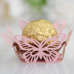 Macro detail of laser-cut pink butterfly candy holder with gold chocolate truffle